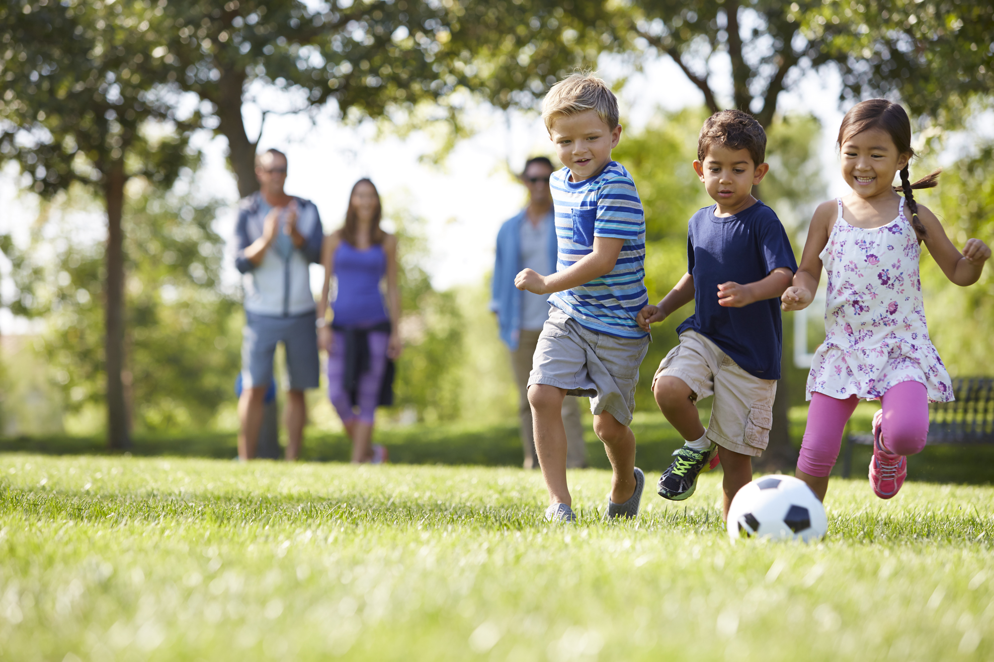 Elementary school kids playing soccer in the park
